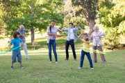 Extended family playing with hula hoops on a sunny day